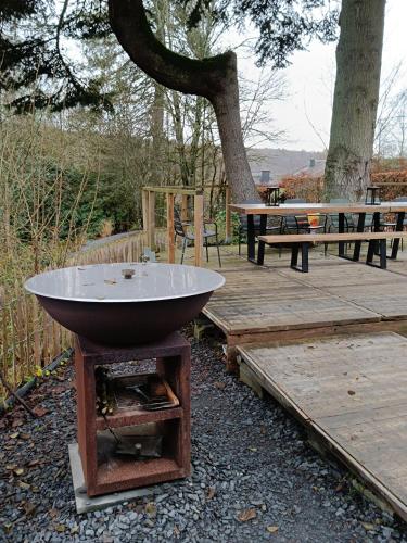 a bowl sitting on a stand next to a wooden deck at La Babillarde in Auby-sur-Semois