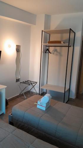 a room with a bed and a table and shelves at Rainbow Sweet Rooms in Valmontone
