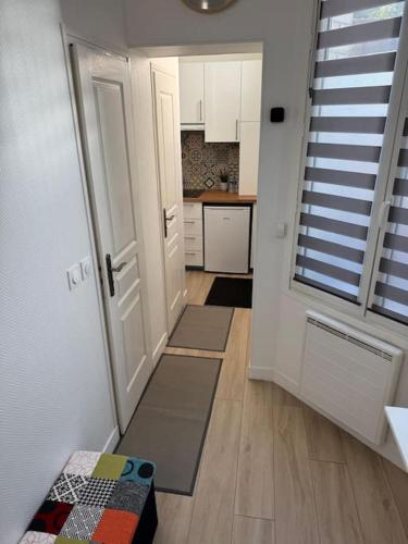 un couloir avec porte et une cuisine avec tapis dans l'établissement studio portes de paris - Arago, à Saint-Ouen