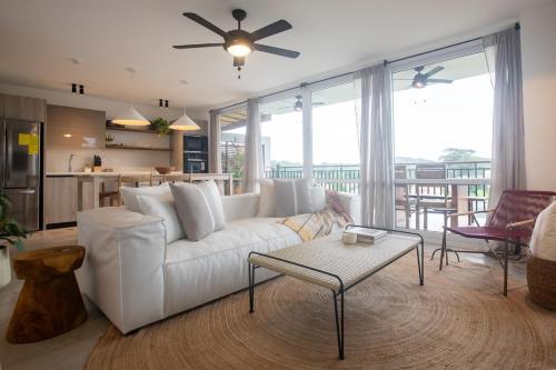 a living room with a white couch and a table at Tasteful View 2BR Condo E31 at Playa Venao in Playa Venao