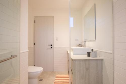 a white bathroom with a sink and a toilet at Tasteful View 2BR Condo E31 at Playa Venao in Playa Venao