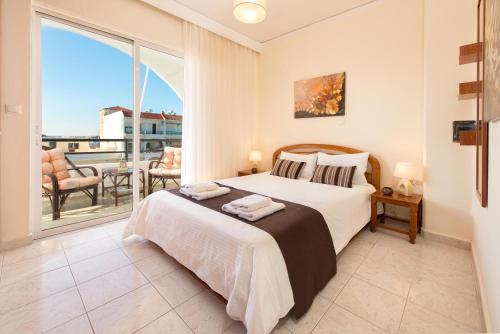 a bedroom with a large bed and a balcony at Apartment Dream Holidays - 500 meters to beach in Ialyssos