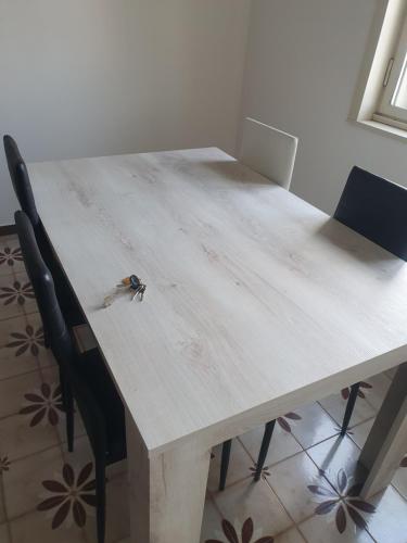 a small bird sitting on top of a wooden table at Dc apartment in Santa Maria Capua Vetere