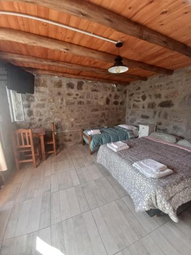 a bedroom with two beds and a wooden ceiling at Complejo vacacional Piedra&Sol in Trapiche