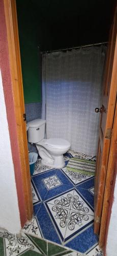 a bathroom with a toilet and a tiled floor at Axel Casa in Jaibalito