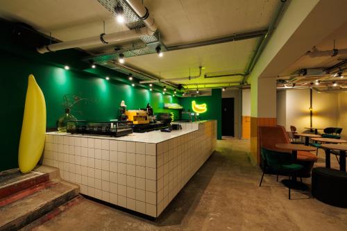 a restaurant with a green wall and a counter at Little Monkey Hostel in Enschede