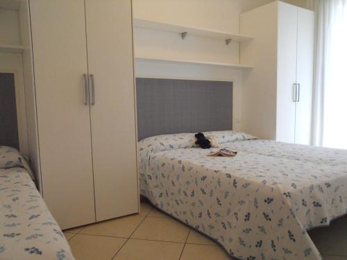Un dormitorio con una cama con un gato sentado en ella. en Villaggio Tulipano, en Bibione