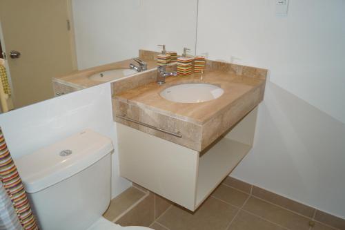 a bathroom with a sink and a toilet at Laguna Bahia Fernanda in Algarrobo