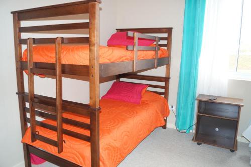 two bunk beds in a room with an orange bed at Laguna Bahia Fernanda in Algarrobo