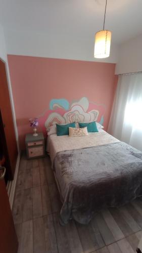 Un dormitorio con una cama grande con un cuadro en la pared. en Apartamento La Loca del Pincel, en Buenos Aires