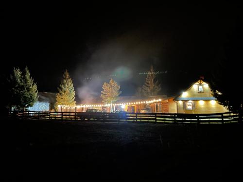 a house lit up at night with lights on it at Chatka Oli in Zubacze