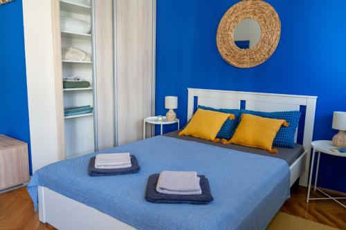 Un dormitorio azul con una cama con toallas. en Home-Like Studio Walking Distance to the Old Town l Washing Machine l Bus Station Nearby, en Novi Sad