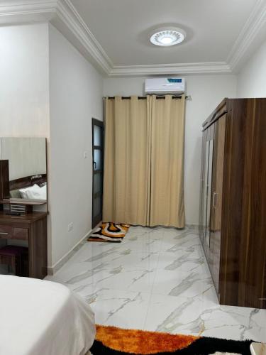 a bedroom with a bed and a curtain in a room at Amsterdam Luxury Plaza in Mbarra Kunku