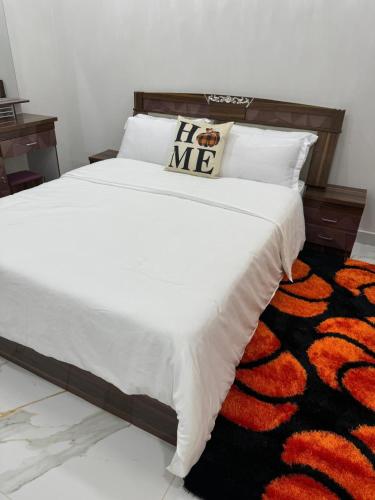 a bedroom with a white bed with a black and orange rug at Amsterdam Luxury Plaza in Mbarra Kunku