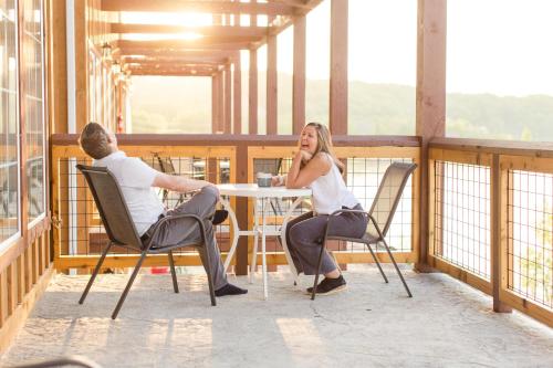 a man and woman sitting at a table on a balcony at Keweenaw Waters Resort in Houghton