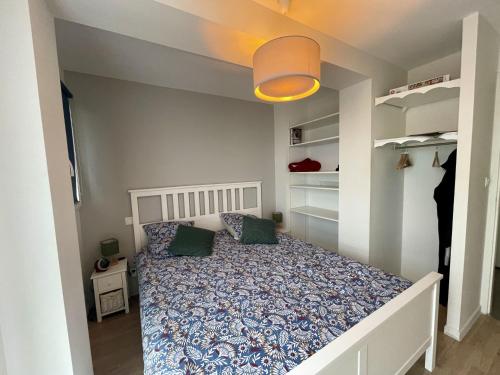 - une petite chambre avec un lit et des étagères dans l'établissement La Rose des Sables, à Saint-Gilles-Croix-de-Vie