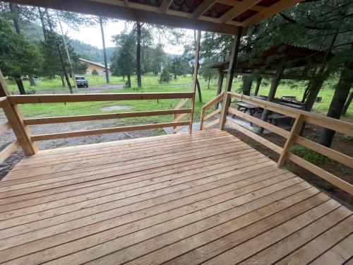a wooden porch with wooden fences and a view of a field at Tranquila Cabaña en la Sierra - Parque La Pirámide in La Florida