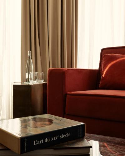 a book on a table next to a chair and a bottle at Marly Boutique Hôtel in Casablanca