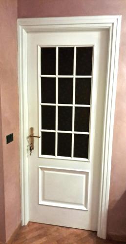 a white door with a window in a room at Luna del Belvedere in Asti