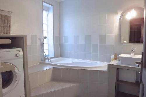 a white bathroom with a tub and a sink at Rosalina - Honfleur in Équemauville