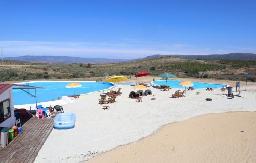 a beach with chairs and umbrellas on the sand at PH in Alto Douro Vinhateiro in Urros