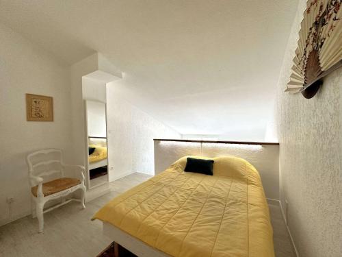 une petite chambre avec un lit et une chaise dans l'établissement HYEVASS Studio pour 4 personnes proche de la plage des Salins situé à Hyères, à Hyères
