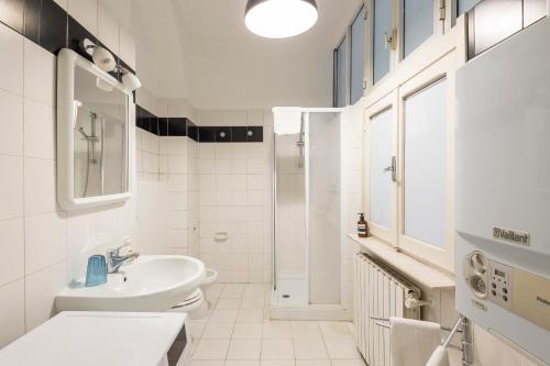 a white bathroom with a sink and a shower at Piazza Navona Charming Large Apartment in Rome