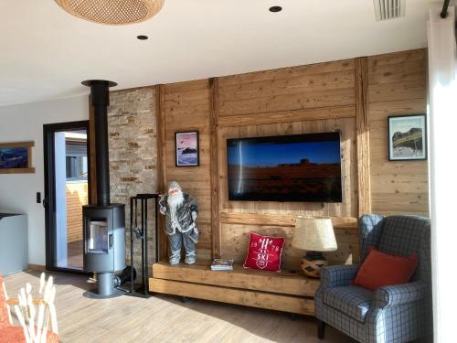 a living room with a television and a statue of a man at Le chalet Paula in Agos-Vidalos