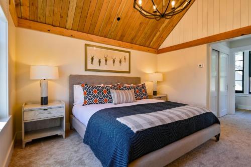 a bedroom with a bed and a wooden ceiling at Mariposa-Valerian-Paintbrush Bundle at Academy Place in Crested Butte