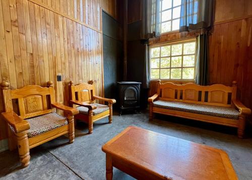 a room with two beds and a table and a window at Encantadora Cabaña del Lago - Parque La Pirámide in La Florida
