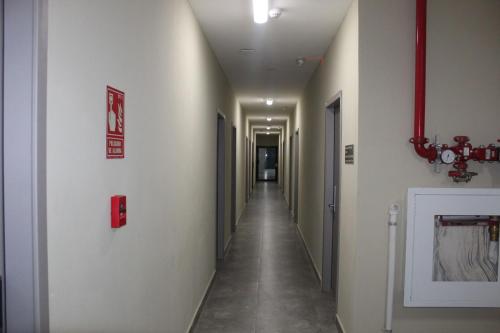 a hallway with a long corridor with many doors at Hotel Plaza Corotú-HPC in Santiago