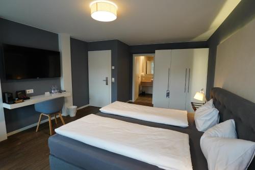 a hotel room with two beds and a tv at wolke 4 in Büren an der Aare