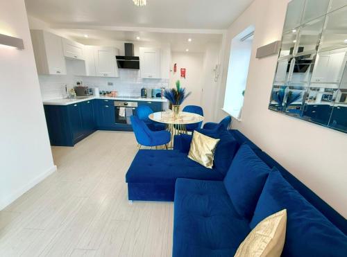 a living room with a blue couch and a table at Winners of 2025 traveller Award, Elegant two bedroom city central apartment with Netflix & WiFi in Leeds