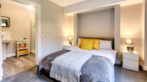 a bedroom with a large bed with yellow pillows at TheLodge in Arrochar