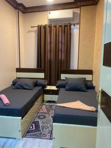 a bedroom with two beds and a curtain at Sunrise shiny Nubian Guest House in Aswan