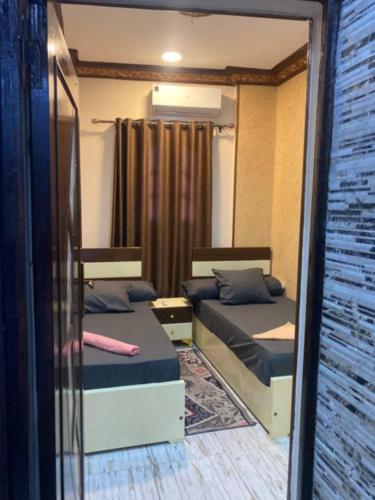 a room with two beds and a window at Sunrise shiny Nubian Guest House in Aswan