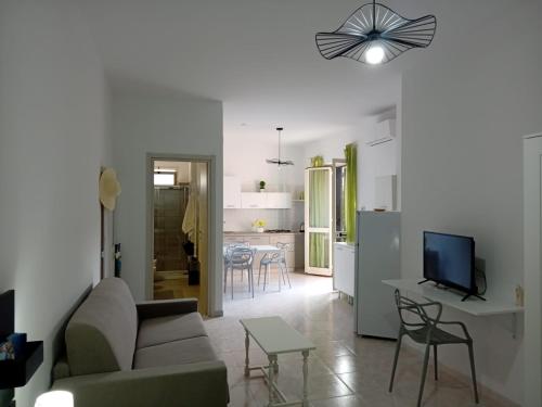 a living room with a couch and a tv and a kitchen at Marica House Spiaggia Coreca Amantea in Amantea