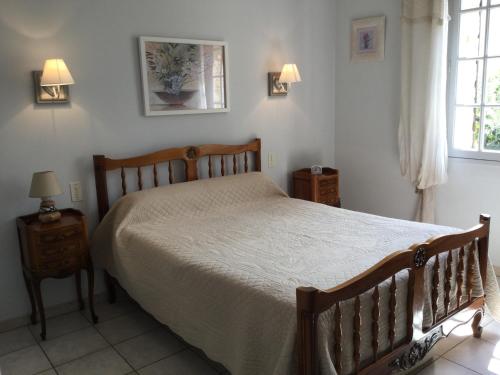 a bedroom with a bed and two night stands and a window at Maison avec piscine privative Taillades Luberon LS2-281 in Les Taillades