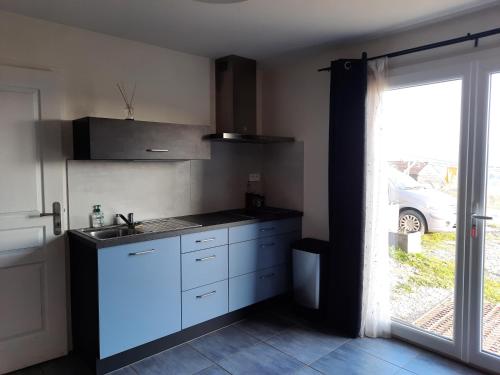 - une cuisine avec un évier et un comptoir avec une fenêtre dans l'établissement Le nid douillet, à Auzits