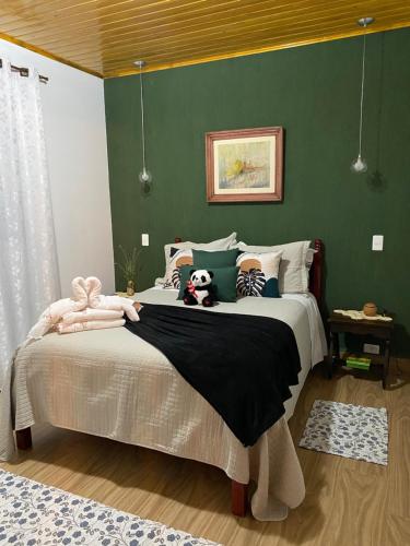 a bedroom with a large bed with green walls at Casa Aconchegante na Montanha in Campos do Jordão