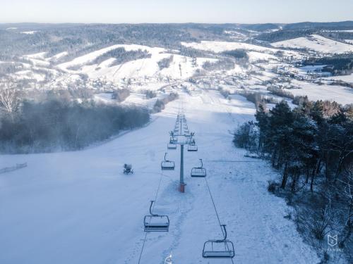a ski lift going down a snow covered slope at Chata w Bieszczadzie apartamenty i domki z basenem Bieszczady in Polańczyk