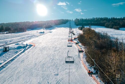 a ski lift with people on it in the snow at Chata w Bieszczadzie apartamenty i domki z basenem Bieszczady in Polańczyk