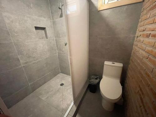 a bathroom with a shower and a toilet at Hermosa Cabaña de Montaña - Parque La Pirámide in Las Adjuntas