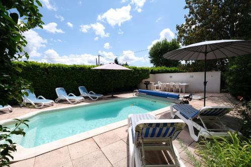une piscine avec des chaises et un parasol dans l'établissement Maison avec piscine privative Mouries Alpilles LS1-308, à Mouriès