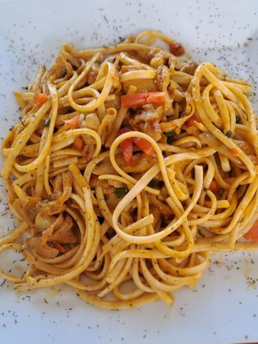a pile of spaghetti on a white plate at H0TELIER Home, Máncora in Máncora