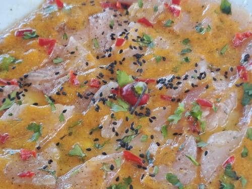 a close up of a dish of food with seasoning at H0TELIER Home, Máncora in Máncora