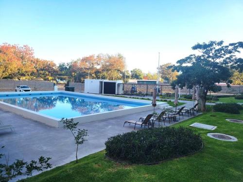 a large swimming pool with chairs in a yard at Condo PH Lago Luna, Chante in Chantepec