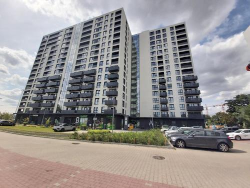 a large building with cars parked in front of it at 1130 Wojciechowskiego 6A - Tanie Pokoje w Apartamencie - samodzielne zameldowanie in Poznań