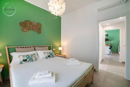 a bedroom with a white bed with a green wall at Marina Verde in Borgio Verezzi
