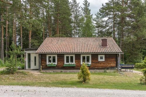 a small wooden house in the middle of a forest at Molnbyggen Strand, Leksand in Leksand